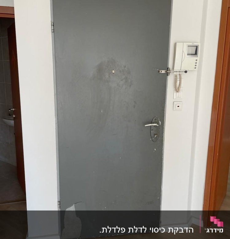 דלת אפורה עם קילופי צבע ותיקון נדרש